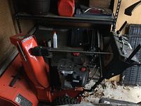 Full view of orange Ariens snowblower showing engine, chute, controls, and tires.