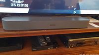 Front view of Sonos soundbar on shelf in front of TV