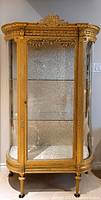 Front view of full cabinet showing curved glass and gilt frame