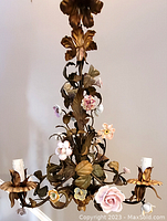 Top portion of chandelier showing gilt metal leaves and hanging chain