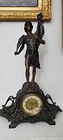 Full frontal view showing statue, ornate base, and clock dial