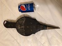 Bellows laid flat with Pepsi can for size comparison, showing overall shape, embossed decorative leather, rivets, and metal nozzle.