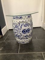 Full front view of porcelain garden stool with glass top