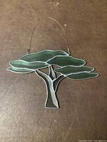 Stained glass tree suncatcher lying flat showing full detail of green leaves and gray-white trunk.