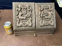 Top exterior showing detailed carved designs including serpent motif on hinged panels.