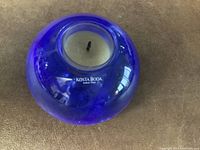 Top view of cobalt blue glass candle holder showing branding 'Kosta Boda' on surface.