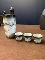 Full set of the sake bottle and three matching cups on a table