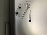 Image showing sterling silver necklace with blue stone pendant and matching blue stone earrings in a box.