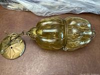 Full view of vintage amber glass swag lamp showing ribbed glass shade and metal mounting chain.