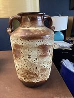 Front view of the large floor vase showing its mottled brown and cream fat lava glaze and dual handles.
