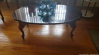 Front angle view of wooden coffee table showing surface and legs, placed on hardwood floor