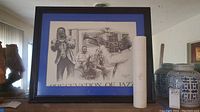 Framed art print showing jazz musicians, signed by Ken Burke, 1990 with a visible chip on the black frame.
