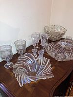 Photo of glass stemware, bowls and vases arranged on wooden surface