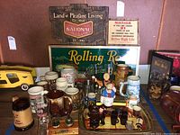 Overview photo showing the bar signs including the Rolling Rock plastic sign and National Beer wooden sign, along with assorted mugs, glasses, shot glasses, and a serving tray.