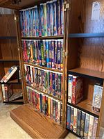 Bookshelf full of Disney VHS movies, showing multiple shelves packed with cases.