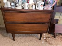 Front view of a single nightstand with decorative items on top.