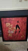 Full view of the framed abstract canvas art with a female figure on a red and gold textured background.