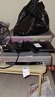 Samsung Blu Ray and Trutech DVD/VCR players stacked, showing cables and remote included