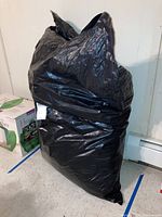 Black plastic bag containing the folded SUV car cover, providing size impression and packaging condition.