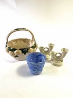 All four items arranged on white surface in bright light: Casafina basket planter, blue glass planter, and two Abingdon cream candle holders.