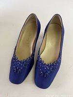 Front view of both blue ladies dress shoes showing decorative beadwork on the toes.