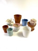 Eight planters displayed including terracotta and ceramic varieties with a seed bomb kit in the natural terracotta planter.