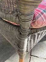 Close-up of corner showing detailed wicker weaving and wrapped support with visible wear and loosened strands.