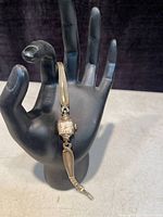 Full view of the Tudor ladies watch displayed on a black hand prop