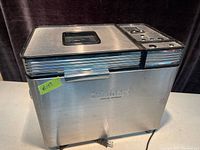 Front and side view of Cuisinart convection bread maker showing stainless steel body, power cord, and control buttons.