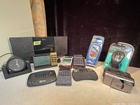 Front view of entire lot showing Sony radio, calculators, clocks, camera, mouse and earbuds