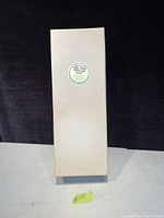 Original beige box upright with a small sticker showing the name and price.
