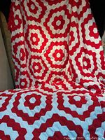 Full view of red and white geometric hex pattern side of the quilt.