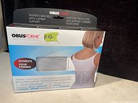 Photo of the Obusforme women's back belt with lumbar support in original box packaging showing product image and branding.