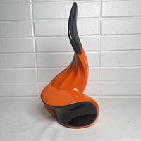 Front-side view showing twisted organic form blending orange and black glaze