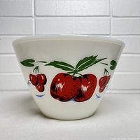 Front view of Fire King bowl showing cherry motif clearly and bowl shape.