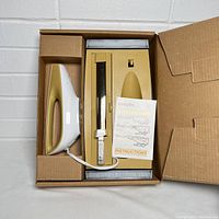 Set in original box showing electric knife, holder, blade, and instruction manual.