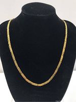 Full-length view of gold chain draped on display bust