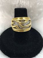 Front view of ring on black stand showing abstract white gold channels set with diamonds