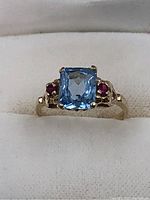 Front view of ring showing rectangular aquamarine and side rubies