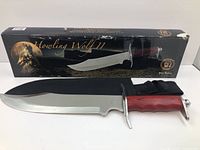 Photo showing the Howling Wolf II knife with 17.5 inch stainless steel blade, pakkawood handle, and black nylon sheath along with the original box.