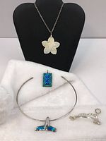 Four pieces of silver jewelry: choker with opal whale tail pendant, turtle pendant with chain, Thomas Sabo bracelet, and a rectangular blue-green enamel pendant