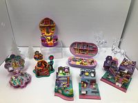Group shot of six open and closed Polly Pocket playsets with crystal tree props