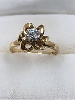 Close-up of 14Kt yellow gold ring with round cut diamond in floral setting