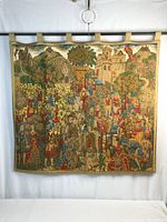Front view of the tapestry showing the entire medieval scene with multiple figures in colorful attire and landscape with castles and hills.