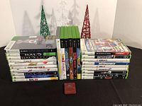Stack of Xbox 360 game cases showing various game titles along with Xbox 360 Kinect sensor box (seller stated, not visible in image). Games titles visible include Halo 3, HALO Reach, FIFA Soccer 10, NHL 15, Link, Battlefield 3, Rayman among others.
