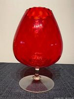 Full view of the red optic glass snifter showing its overall shape and color with clear stem and base.