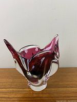 Front view showing smooth flowing curves and cranberry color blending into clear glass