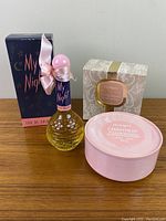Photo showing My Night Eau De Cologne perfume bottle with its dark blue box, and Chantilly dusting powder with its pink lace-patterned box.