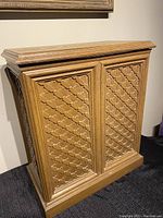 Front view of vintage 1970s wooden laundry hamper with vented lattice panel design on sides and front.