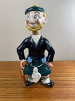 Front view of the ceramic Scottish man decanter showing details of clothing and pose